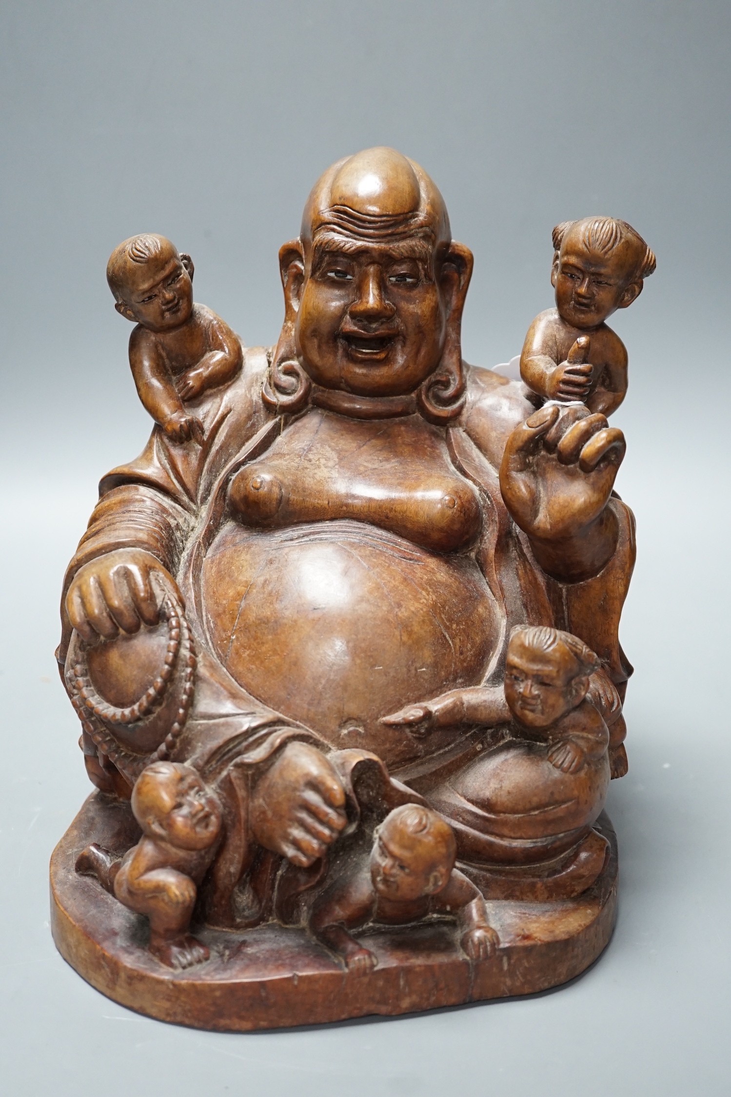 A Chinese carved wood group of Budai, 24cm